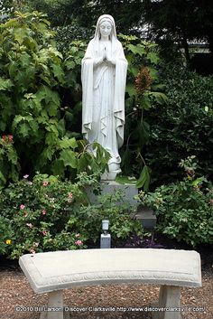 a white bench sitting in front of a statue