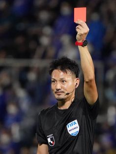 a man holding up a red card in the air