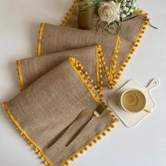 three placemats with yellow trim on them and a cup of coffee next to it