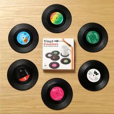 six different colored records sitting on top of a wooden table