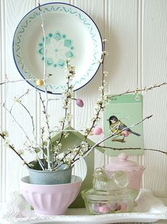 a vase filled with flowers sitting on top of a wooden table next to a plate