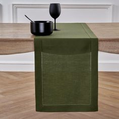 a green table runner with a black pot on it