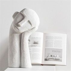 an open book with a white towel wrapped around it on top of a table next to a stuffed animal