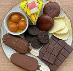 a plate filled with chocolate, oranges and crackers on top of a wooden table