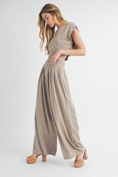 This Solid Crop Top & Pleated Wide Leg Pants set is a must-have for any formal occasion. With its simple and classic design, it offers an effortless yet elegant look. The short sleeve crop top and wide leg pants provide a comfortable fit, while the pleated details add a touch of sophistication. Perfect for any fashion-forward individual. Elegant Solid Cropped Crop Top, Spring Business Casual Wide Leg Sets, Summer Workwear Crop Top With Short Sleeves, Fitted Cropped Wide Leg Pants For Work, Elegant Cropped Wide Leg Pants For Work, Chic Cropped Bottoms For Formal Occasions, Elegant Cropped Wide Leg Pants, Chic Short Sleeve Workwear Sets, Elegant Solid Color Short Sleeve Sets