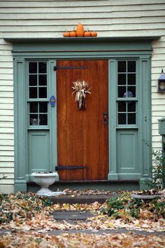 a front door with two pumpkins on it