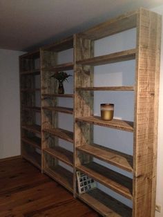 a wooden shelf filled with lots of shelves next to a wall mounted vase and potted plant