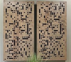 two wooden wall art pieces with holes in them and a potted plant next to it