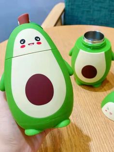 a green and white toy sitting on top of a wooden table next to another toy