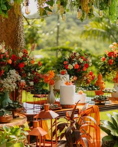 there are many different types of flowers on the table and in front of them is a cake