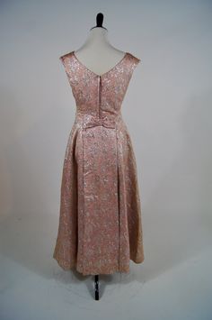 "Wowzers! This vintage 1950s Ann's vogue Shoppe gown is a stunner! It is a full length pink and silver brocade gown with sequin and beaded appliqué on the shoulder. It zips up the back (the original zipper has been replaced) and has a bow at the lower back. It is fully lined in pink acetate and is in excellent condition but does have areas of discoloration in skirt folds and under the arms. Size: M Bust: 34\" Waist: 29\" Hips:Open Length: 52\"" Pink Brocade Dress, Evening A-line Brocade Dress, Skirt Folds, 1950s Pink Evening Dress, 1950s Brocade Dress, Brocade Gown, 1950s Pink Sleeveless Dress, Hip Openers, Pink And Silver