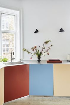 a vase with flowers sitting on top of a kitchen counter