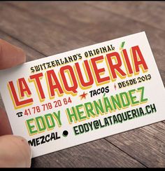 a person holding up a business card with the words la taqueria on it