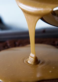 a chocolate cake with caramel sauce being poured onto it