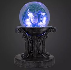 a glass ball with a woman's face inside it on top of a pedestal