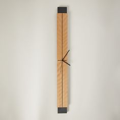 a wooden clock with black hands on a white wall