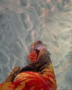 a woman laying on top of a sandy beach