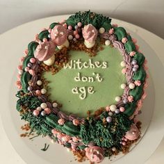 a cake decorated with pink and green frosting that says witches don't age