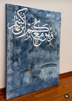 a painting with arabic writing on the side of a wooden floor next to a wall