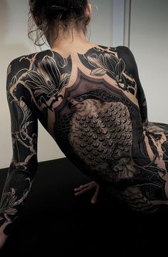 the back of a woman's body covered in tattoos