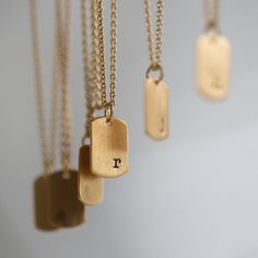 "Keep your loved ones close at heart with our tiny yet impactful Initial Mini Tag Necklace. This necklace was designed to be a feminine take on the dog tag necklace. Select your initial or diamond dusted texture for your pendant. Each letter is individually stamped by hand right justified in the bottom corner of the pendant, making each tag one of a kind. details + mini tag measures .5\" long x 5/8\" wide + on model : 16 & 18\" adjustable necklace + s hook closure + handmade with love in our Large Pendant Necklace, Hand Stamped Necklace, S Hook, Adjustable Necklace, Dog Tag, Dainty Necklace, Unique Necklaces, Tag Necklace, Initial Necklace