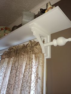 the curtain rod is attached to the top of the shelf above the window sill