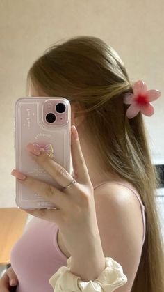 a woman taking a selfie with her cell phone in front of her face and wearing a pink dress