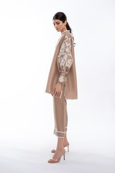 A tan rawsilk shirt features floral appliqué work on gathered sleeves and scallop detailed edges. Paired with matching rawsilk culottes. Model Height is 5'10 and Shirt Length is 33' Pak Suits, Coordinated Sets, Appliqué Work, Cotton Suit Designs, Sleeveless Blouse Designs, Kurta Shirt, Co Ords Outfits, Asymmetrical Coat, Edge Fashion