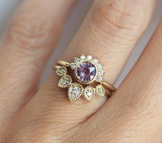 a woman's hand with a ring on it and a pink stone in the middle