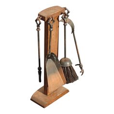 an old fashioned wooden tool holder with two tools on it's sides and a broom in the middle