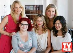 a group of women sitting next to each other on top of a couch in a living room