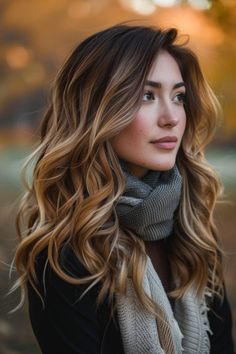 Woman with long wavy hair wearing a scarf gazes into the distance in an autumn setting. Fall Bolyoge Hair, Fall Layered Hair, Ombre Fall Hair Color, Fall Ombre Hair, Fall Hair Highlights, Color Experiment, Warm Hair Color, Fall Hair Color Ideas, Hair 2022