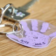 a keychain with a hand print on it and a pair of keys attached to it