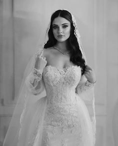 a woman in a wedding dress and veil posing for the camera with her hands on her hips