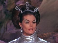 a woman with silver makeup and hair in a scene from the television show star trek