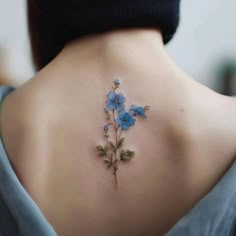 the back of a woman's neck with blue flowers on it