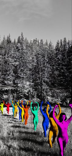 a group of people that are standing in the grass with their hands up and arms raised