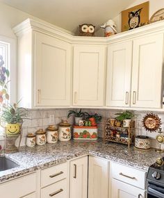 a kitchen with white cabinets and granite counter tops