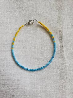 "I reccomend that you measure your ankle and send me the length desired in a note or message. That way I can tailor the length to your personal specifications. If you do not notify me of the size needed, you will get the size selected at checkout with a 2\" extender chain. This anklet is made with light blue, turquoise, and sunshine yellow seed beads. They are strung onto beading wire and finished with a silver color lobster claw clasp and two inch extender chain. Size Options: 8\" adjustable to Summer Anklets Diy, Seed Bead Bracelet Ideas, Seed Bead Anklet, Seed Bead Bracelets Tutorials, Diy Earrings Easy, Bead Anklet, Beaded Braclets, Womens Ankle Bracelets, Surf Jewelry