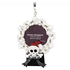 an ornament with a skeleton holding a red hat and bow on it's head