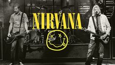 two men are playing guitars on stage with the words nirvana in front of them and an image of a smiling face