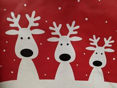 three reindeers are standing in front of a red background with white snowflakes