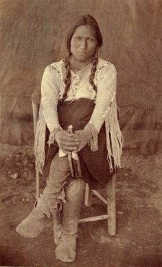 an old black and white photo of a native american woman sitting in a rocking chair