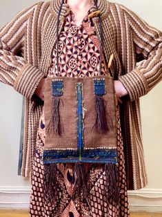 "Here is a great vintage bag. It is a woven from a brown wool that feels course. It has a black, blue and green embroidery adorning the bottom and at the front and back of the bag. It has fringe at the bottom of the bag and on the front of the bag. The fringe is so fine and almost has the look of finely braided hair. The straps are braided black wool maybe. The interior is fully lined in a grey cotton. There is no closure to the bag and there is just the one compartment. There are no tags of any Hippie Handmade Brown Shoulder Bag, Hippie Brown Handmade Shoulder Bag, Brown Rectangular Hippie Bag, Vintage Handwoven Satchel Shoulder Bag, Bohemian Brown Woven Shoulder Bag, Artisan Brown Bag With Fringe, Brown Artisan Bags With Fringe, Artisan Brown Bags With Fringe, Artisan Brown Fringe Bag