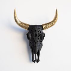 a bull's skull with gold horns on a white background