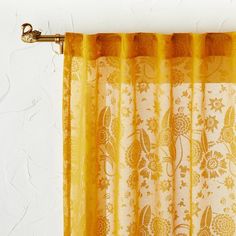 an orange curtain hanging on the side of a white wall