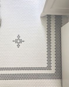 a bathroom with white and gray tiles on the wall