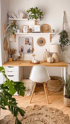 a desk with plants and pictures on the wall