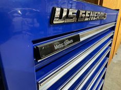 a close up of a blue metal cabinet with chrome lettering on the front and sides