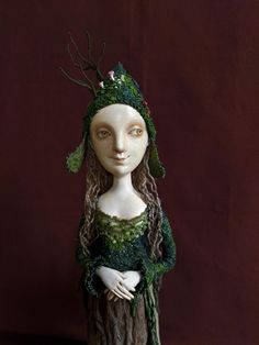 a white mannequin wearing a green dress and headpiece